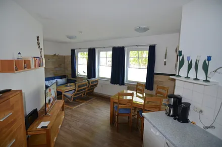 Wohnzimmer mit großem Esstisch, zwei Relaxsesseln und Couch