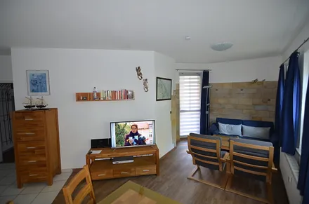 Blick zur Couchecke, die mit Solnhofer Naturstein verkleidet ist, links Balkontür