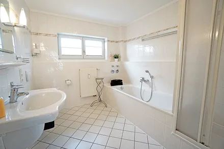 Badezimmer mit Badewanne und Duschkabine