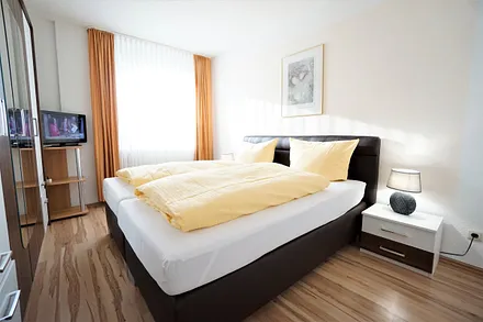 Schlafzimmer mit Doppelbett und Flachbildfernseher