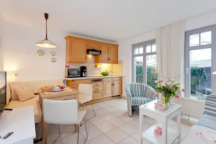  Wohn-, Ess- und Kochbereich mit angrenzender Terrasse mit Strandkorb