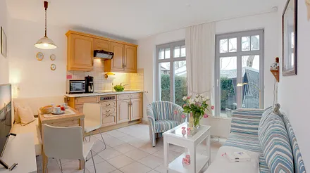  Wohn-, Ess- und Kochbereich mit angrenzender Terrasse mit Strandkorb