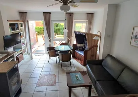 Wohnzimmer mit Kamin und Strandkorb mit Eßplatz für 4 Personen. 