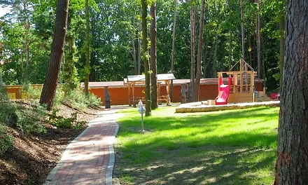 Separater Spielplatz mit Tischtennisplatte in der Anlage hinter einem Erdwall.