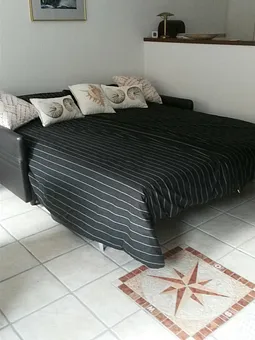 Schlafcouch mit Blick zum Kamin und Fernseher, mit Matratze und Bettkasten . 