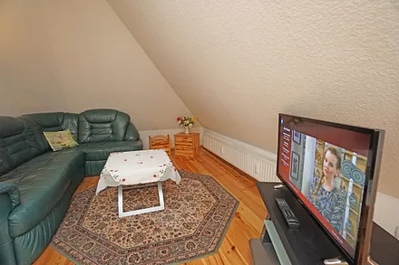 Wohnzimmer mit Schlafcouch und Flachbildfernseher