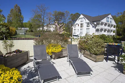 Terrasse mit Sonnenliegen und Gartenstühle