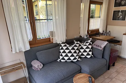 Gemütliche Couch mit Schlafmöglichkeit  und Küchensitzecke im Hintergrund