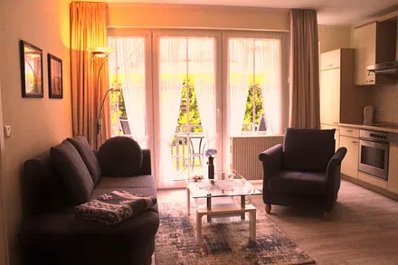 Wohnraum mit integrierter Küchenzeile und Essecke. Die Couch lässt sich zu einer Schlafcouch umfunktionieren.