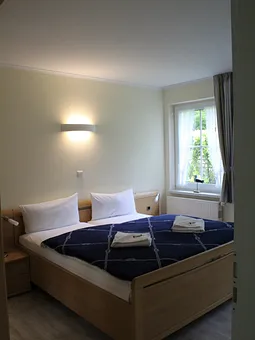 Schlafzimmer mit Doppelbett und Zugang zum Duschbad mit WC.