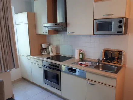 Küchenzeile ausgestattet mit Backofen, Herd, Mikrowelle, Kühlschrank, Geschirrspüler, Toaster, Kaffeemaschine, Wasserkocher und allem was dazu gehört.