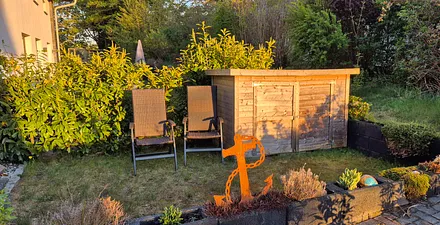 Fahrradschuppen und Abendsonne auf der Wiese an der Terrasse 