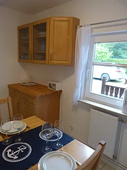 Anrichte in der sich Geschirr, Gläser und Besteck für 6 Personen befindet.