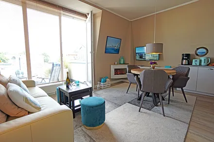 Wohnzimmer mit Esstisch und Zugang zur Dachterrasse