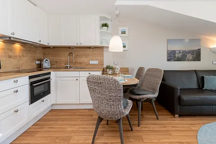 Wohn- und Essbereich, vollausgestattete Einbauküche mit Espressomaschine, Milchaufschäumer, Handrührgerät, Kombimikrowelle, 4-Sterne-Gefrierfach, hochwertiges Arbeitsgeschirr.