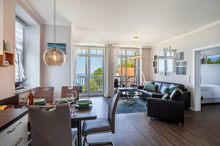 Von der Ganzglastüre im Wohnzimmer empfängt sie der großzügiger Wohnraum mit grandiosem Meerblick.