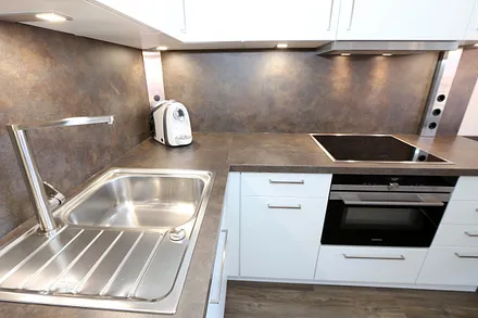 Espressomaschine, Induktionsherd, Kombimikrowelle, 4-Sterne-Gefrierfach, Milchaufschäumer, Handrührgerät, hochwertiges Inventar und Geschirr in ausreichender Anzahl