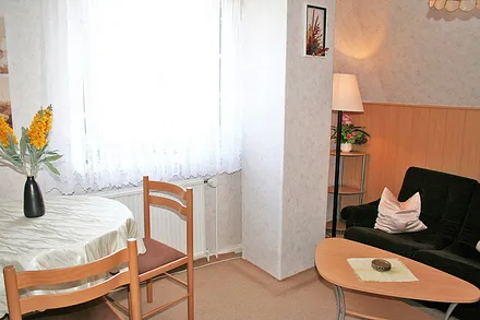 gemütlich eingerichtet mit Tisch, 3 Stühlen und kleiner Couch-Ecke