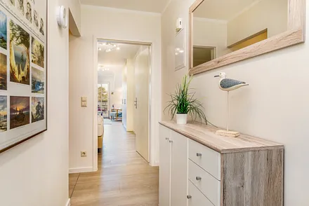 Der Flur mit Garderobe hat links im Bild eine Nische, in der sich die Küchenzeile befindet.