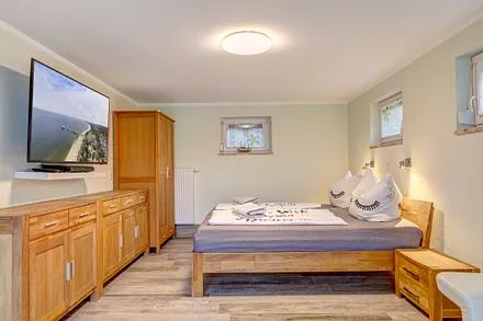 Schlafzimmer mit Doppelbett und TV