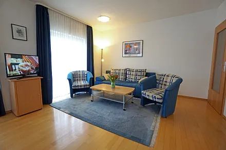 Wohnzimmer mit Flachbildfernseher und Schlafcouch