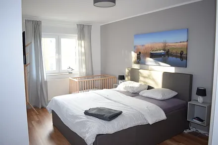 Schlafzimmer 1 mit Babybett und TV