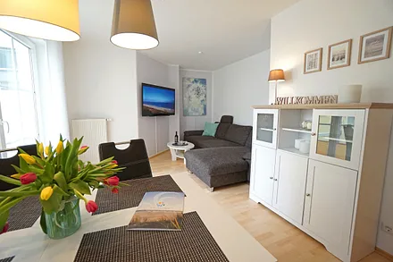 Wohnzimmer mit Schlafcouch und Flachbildfernseher