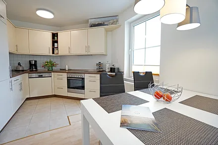 Wohnzimmer mit Esstisch und Küchenzeile