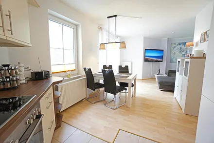 Wohnzimmer mit Küchenzeile, Esstisch, Schlafcouch und TV