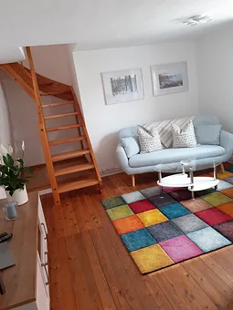 Wohnzimmer mit Treppe zum Schlafzimmer