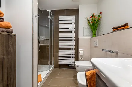 Das schöne Bad mit Dusche, WC, Waschbecken und Fön.