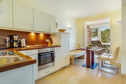 Die Küchenzeile mit Cerankochfeld, Backofen, Mikrowelle, Geschirrspüler und Kühl/Gefrierkombination.