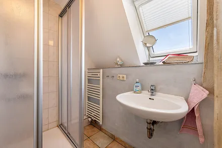Das Bad liegt auf der Ebene des Wohnzimmers im Dachgeschoß.