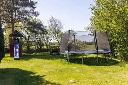 Ein kleiner Spielplatz mit Trampolin und Spielturm kann bespielt werden.