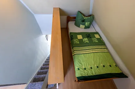 Der Schlafbereich im Spitzboden hat keine Tür zum Wohnbereich.