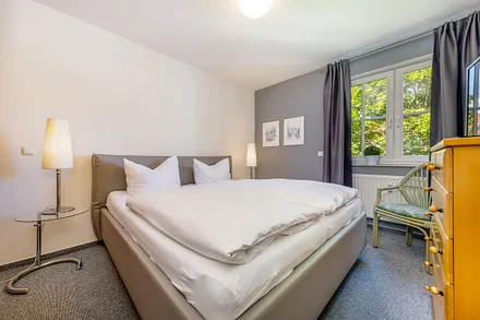 Das Schlafzimmer mit Doppelbett und Außenrolladen am Fenster ... 