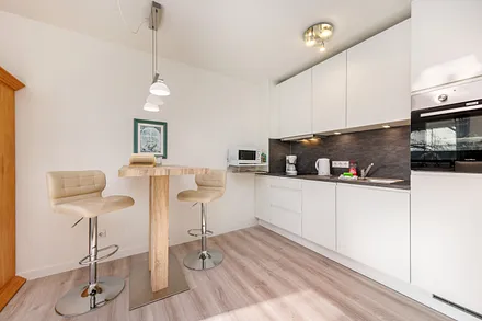 Die Küchenzeile ist ausgetattet mit Cerankochfeld, Backofen, Geschirrspüler, Toaster, Kaffee- und Wasserkocher sowie Kühlschrank mit Eisfach.