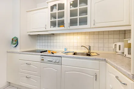 Die Küchenzeile ist ausgetattet mit Cerankochfeld, Geschirrspüler, Toaster, Kaffee- und Wasserkocher sowie Kühlschrank mit Eisfach.