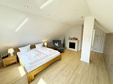 1. Schlafzimmer mit Doppelbett und Elektrokamin