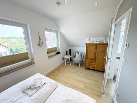 2. Schlafzimmer mit Doppelbett und kleiner Sitzecke