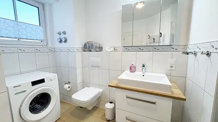 Badezimmer mit WC und Waschmaschine