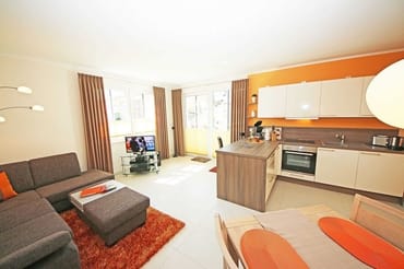 offener Wohnbereich mit Massivholzmöbeln, gemütlicher Eckcouch, Stehlampe, Vitrine, LCD-Flachbild-TV, Yamaha Dolby-Surround-Anlage mit DVD-Player und Radio sowie Bluetooth-Adapter für alle Smartphones