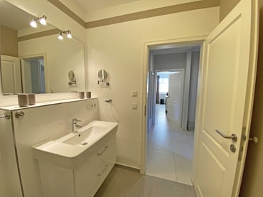 hochwertiges Badezimmer mit ebenerdiger Dusche, Waschplatz, WC, Handtuchheizkörper, Kosmetikspiegel und Fön