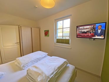 Schlafzimmer mit Doppelbett (2 x 0,90 m x 2,00 m), Nachttischkonsolen, Kleiderschrank und LCD-Flachbild-TV