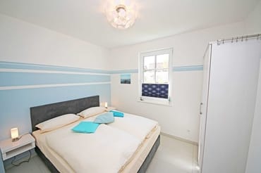 Schlafzimmer mit Boxspringbett (1,60 m x 2,00 m), Nachttischkonsolen und Kleiderschrank