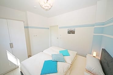 Schlafzimmer mit Boxspringbett (1,60 m x 2,00 m), Nachttischkonsolen und Kleiderschrank