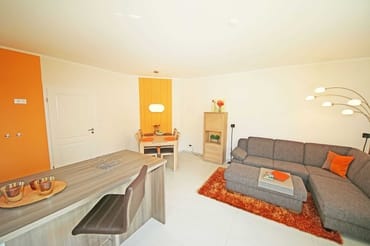 offener Wohnbereich mit Massivholzmöbeln, gemütlicher Eckcouch, Stehlampe, Vitrine, LCD-Flachbild-TV, Yamaha Dolby-Surround-Anlage mit DVD-Player und Radio sowie Bluetooth-Adapter für alle Smartphones