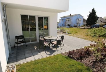 überdachte und bestuhlte Terrasse (Süd) und angrenzende Grünfläche