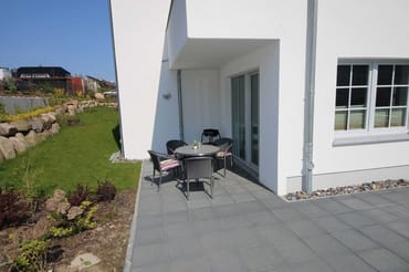 überdachte und bestuhlte Terrasse (Süd) und angrenzende Grünfläche