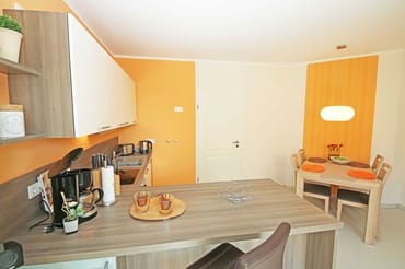 Küchenzeile mit Ceranfeld, Backofen, Geschirrspüler, Mikrowelle, Kühlschrank mit Gefrierfach, Kaffeemaschine, Wasserkocher, Toaster und diversen Küchenutensilien